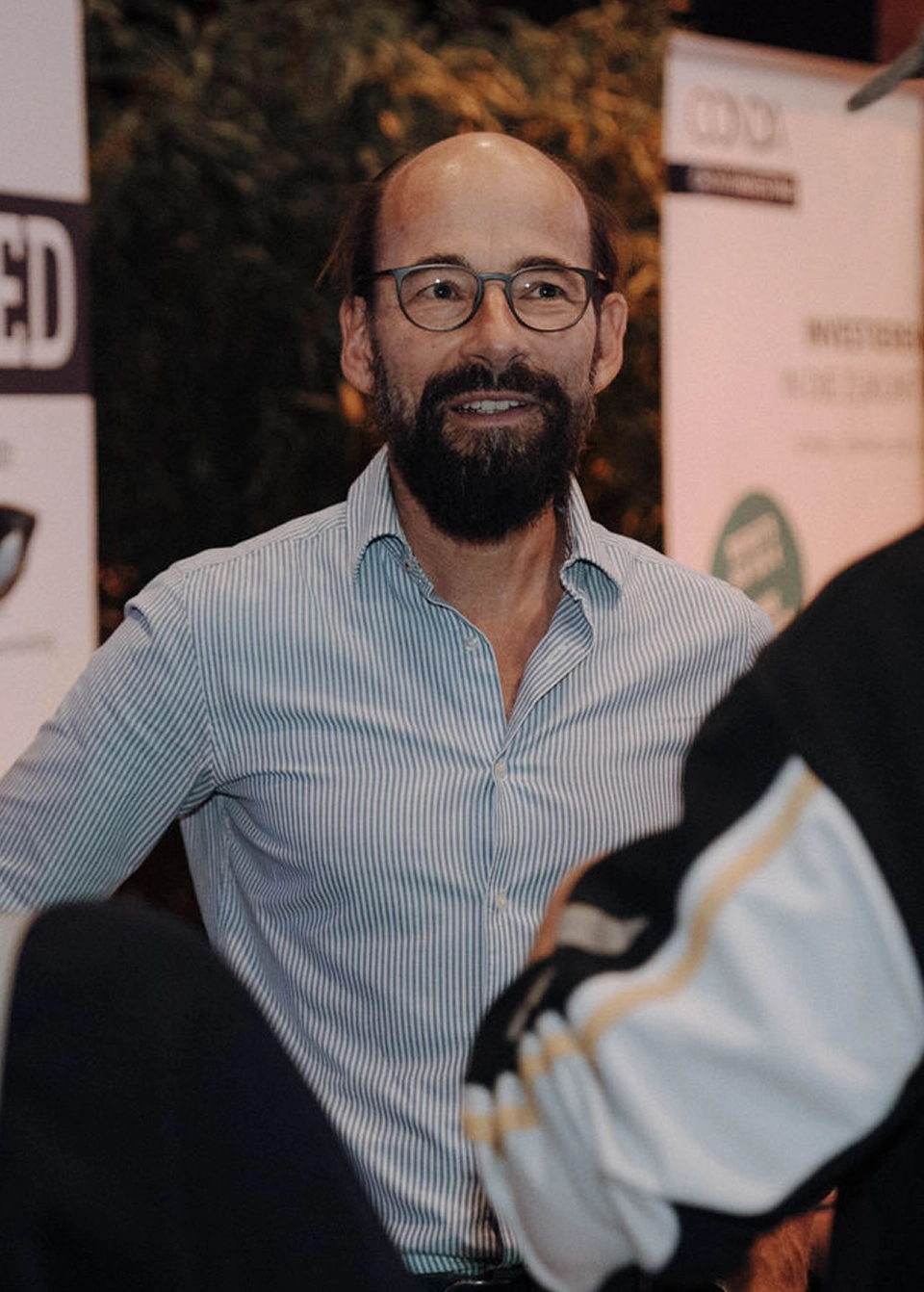 Markus Weiss, Managing Partner und Förderberater bei MINTED, im Gespräch mit einer anderen Person auf einem Event
